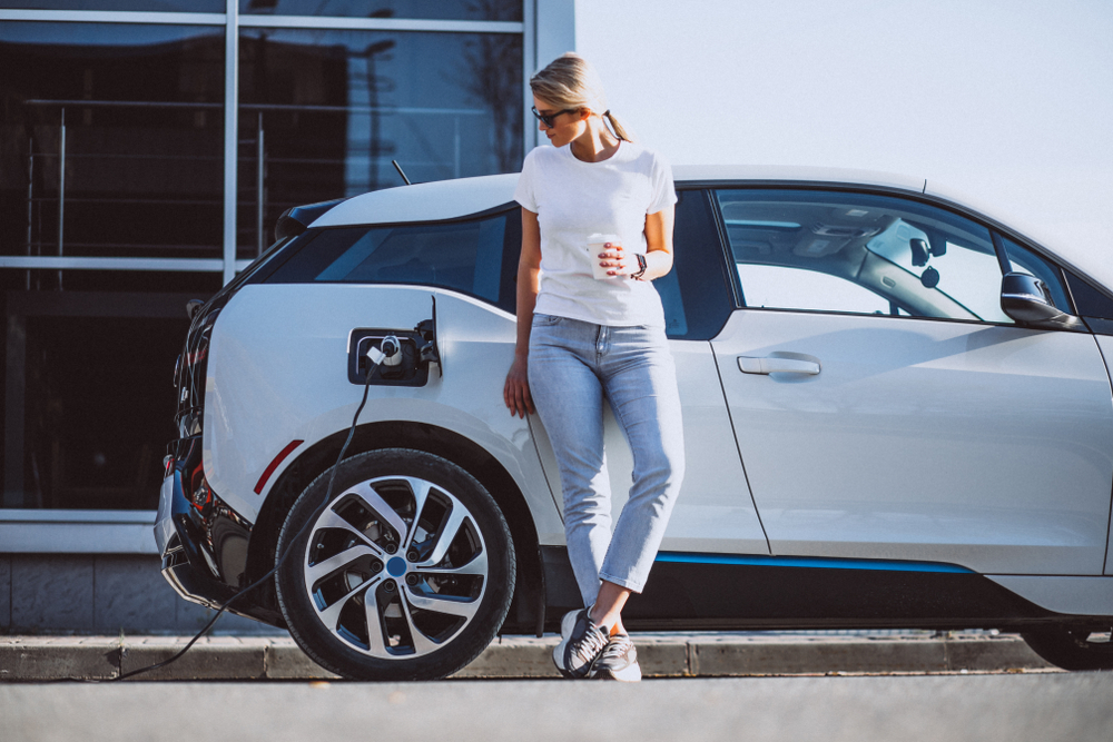 Girl leaning on electric car